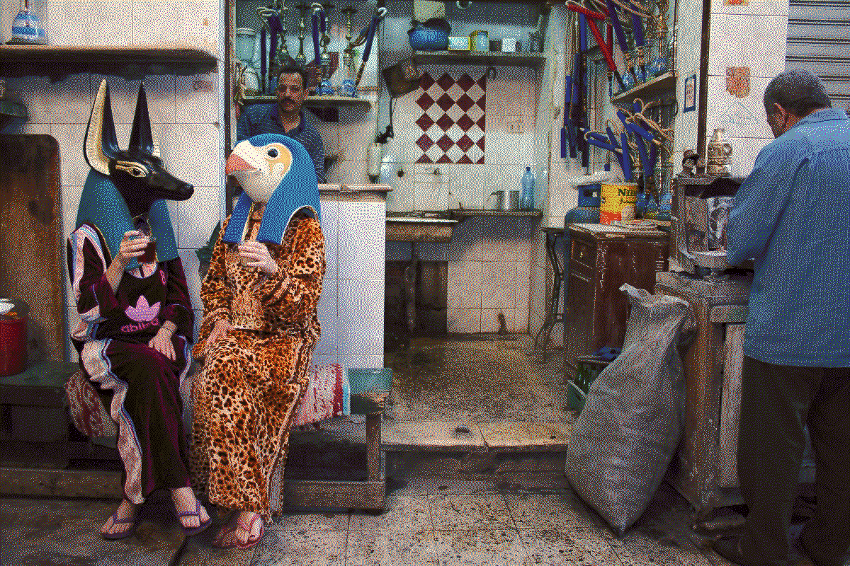two women with anubis and horus mask drinking tea